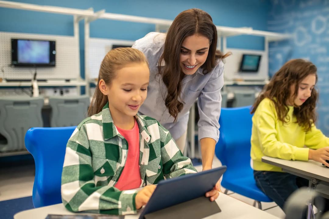Teacher interacting with students using tablets