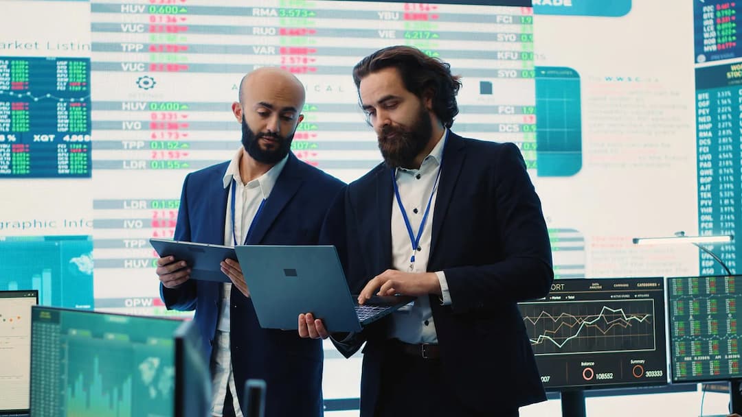 Two financial professionals analyzing data on screens
